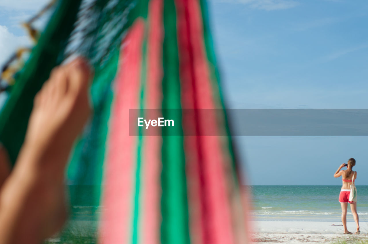 Low section of person on hammock at beach