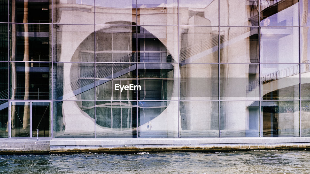 BUILDING SEEN THROUGH GLASS WINDOW