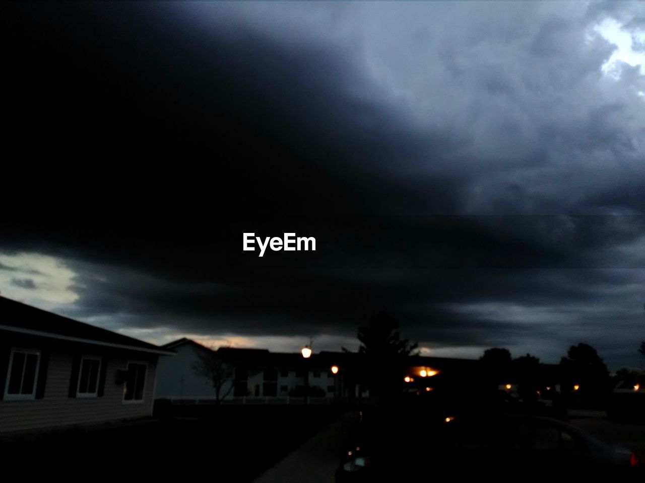 VIEW OF HOUSES AGAINST CLOUDY SKY