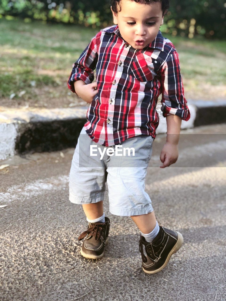 CUTE BOY STANDING ON ROAD