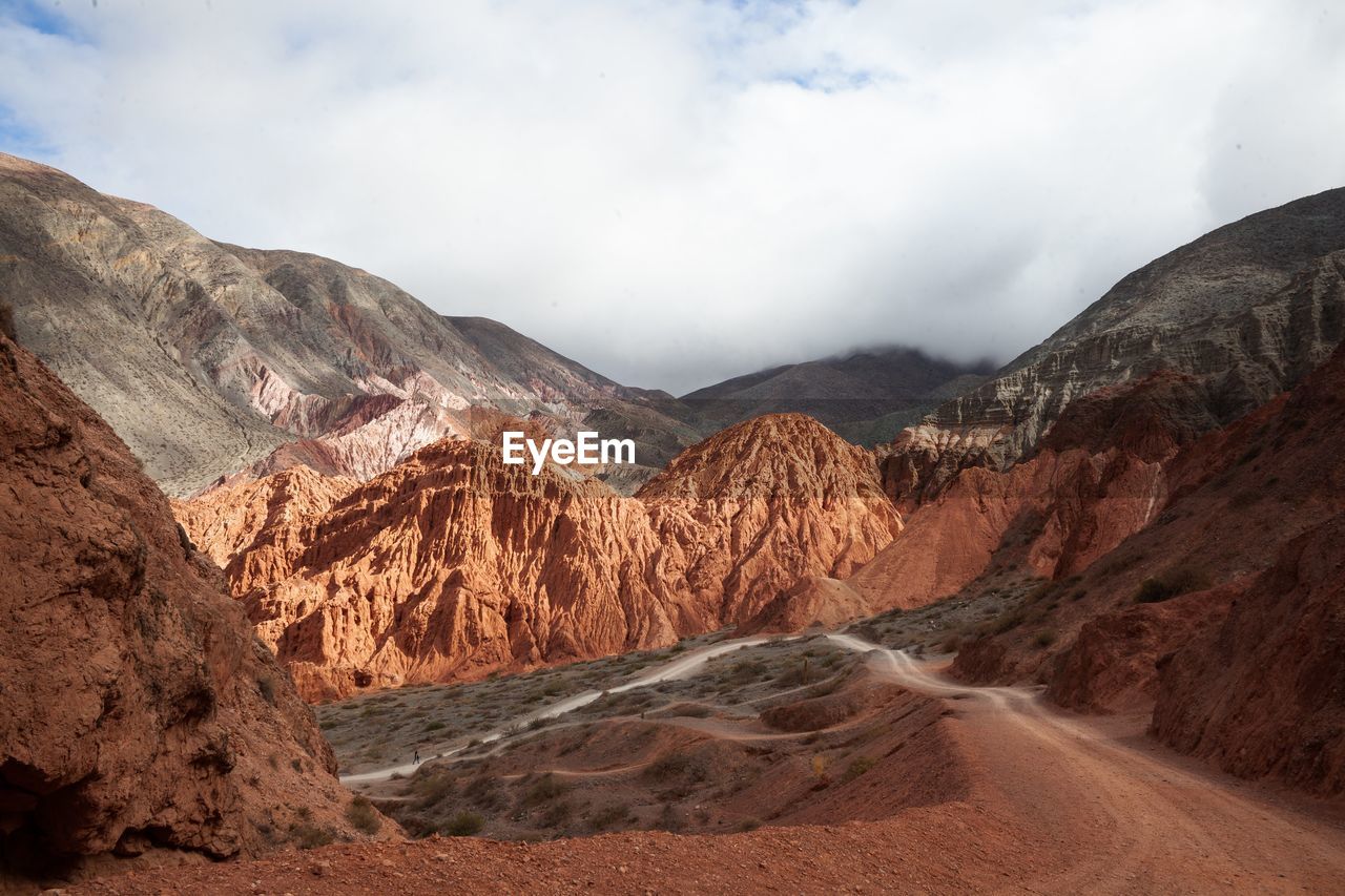 Scenic view of mountain range against cloudy sky