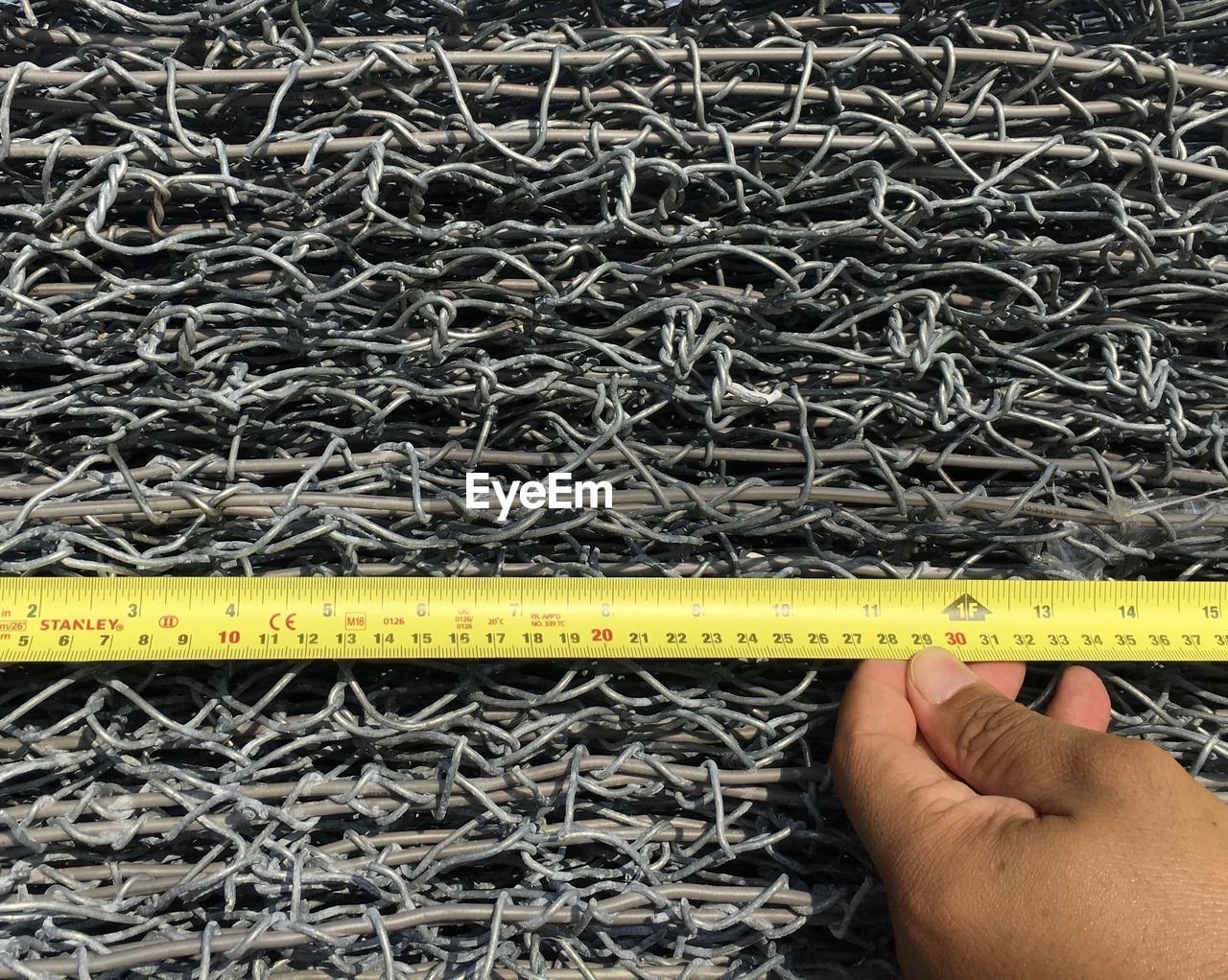 Close-up of hand measuring metal