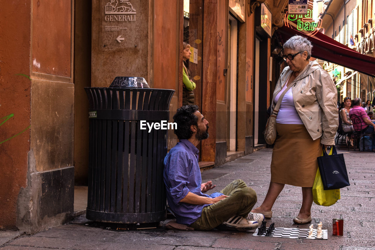 PEOPLE ON STREET IN FRONT OF CITY