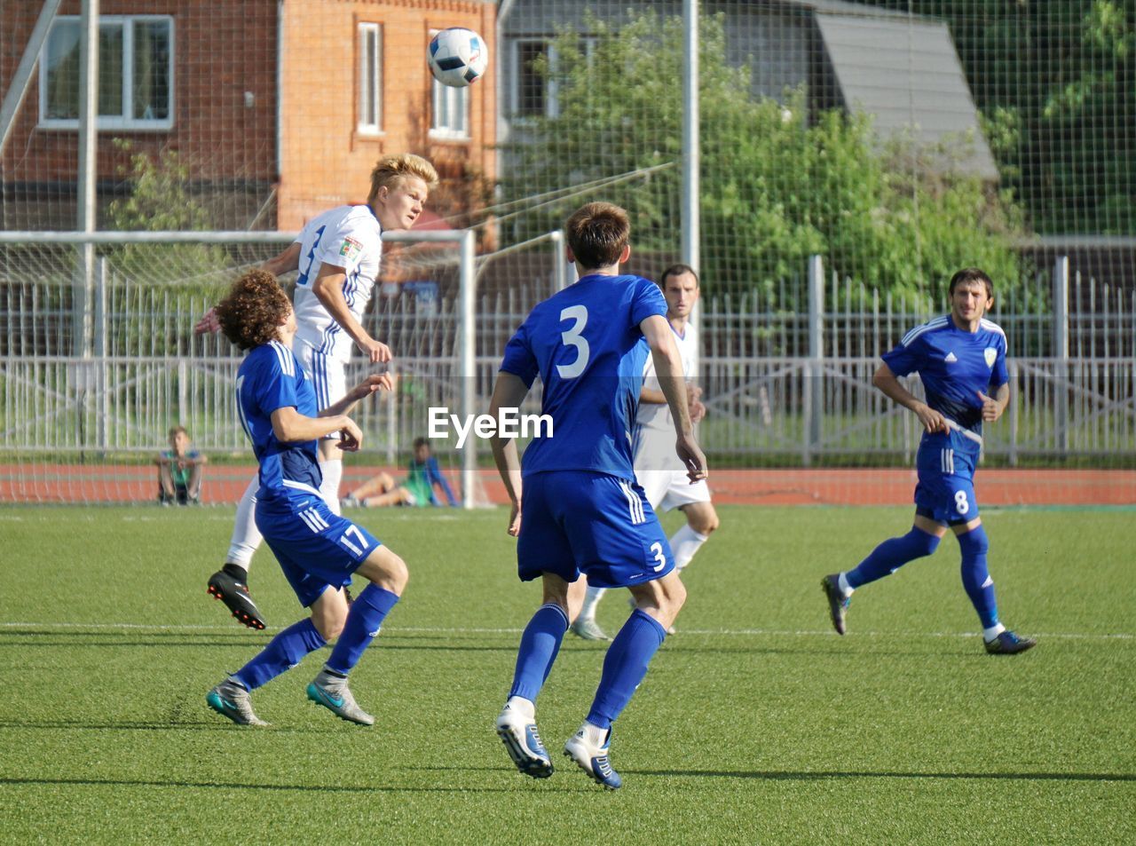 REAR VIEW OF MEN PLAYING SOCCER