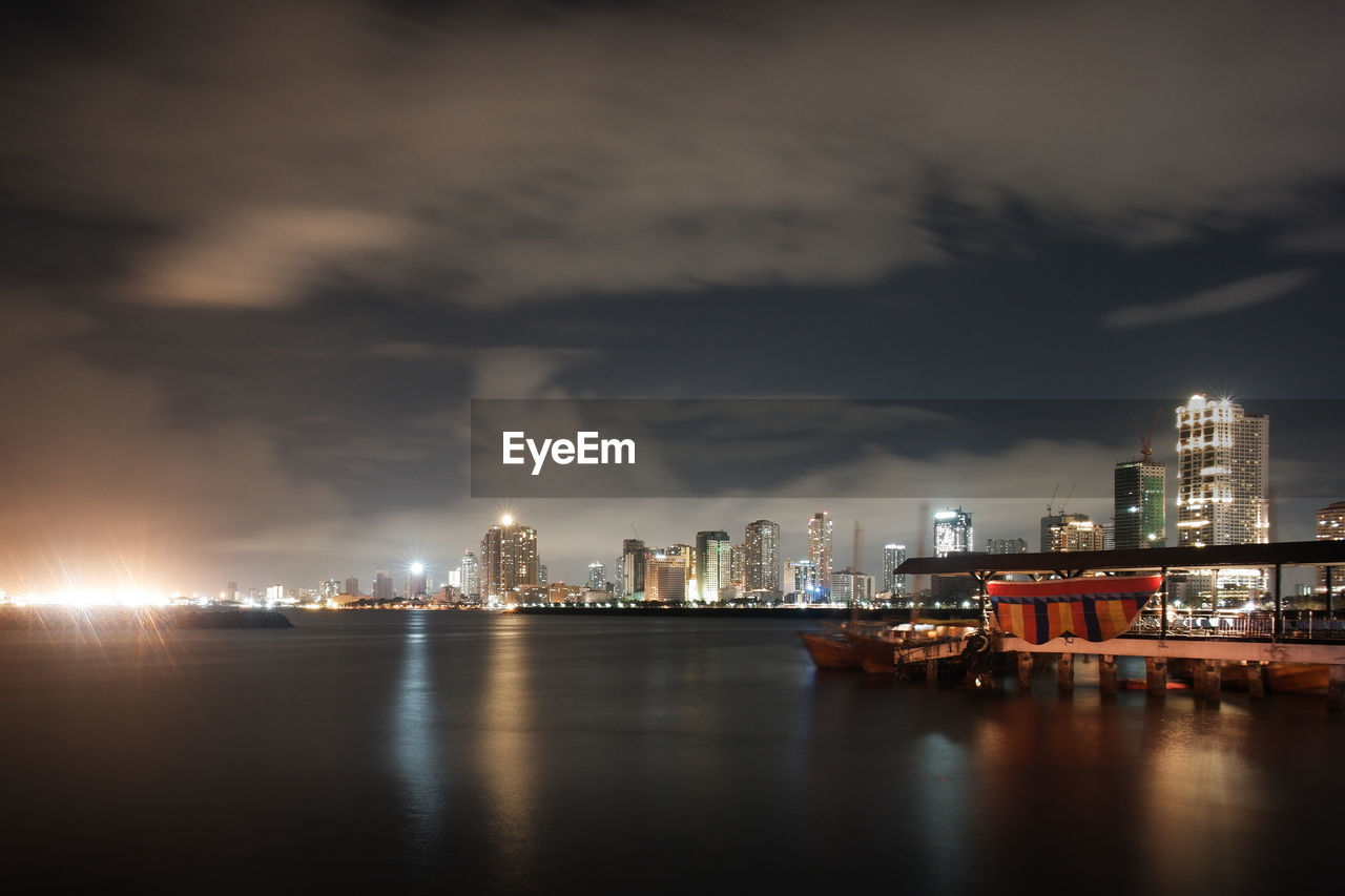 Illuminated buildings in city against sky at night