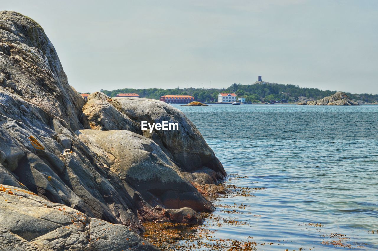 Rock formations by sea against sky