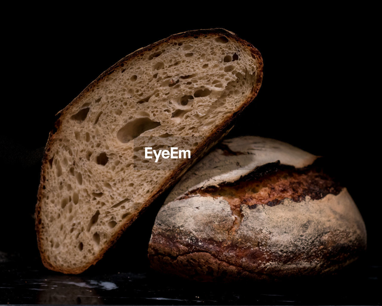 Cut sourdough bread loaf against black background