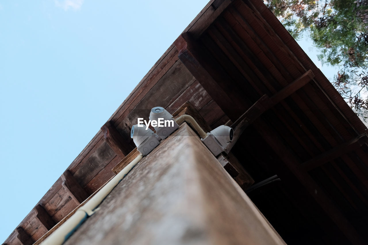 Low angle view of security camera on building against sky