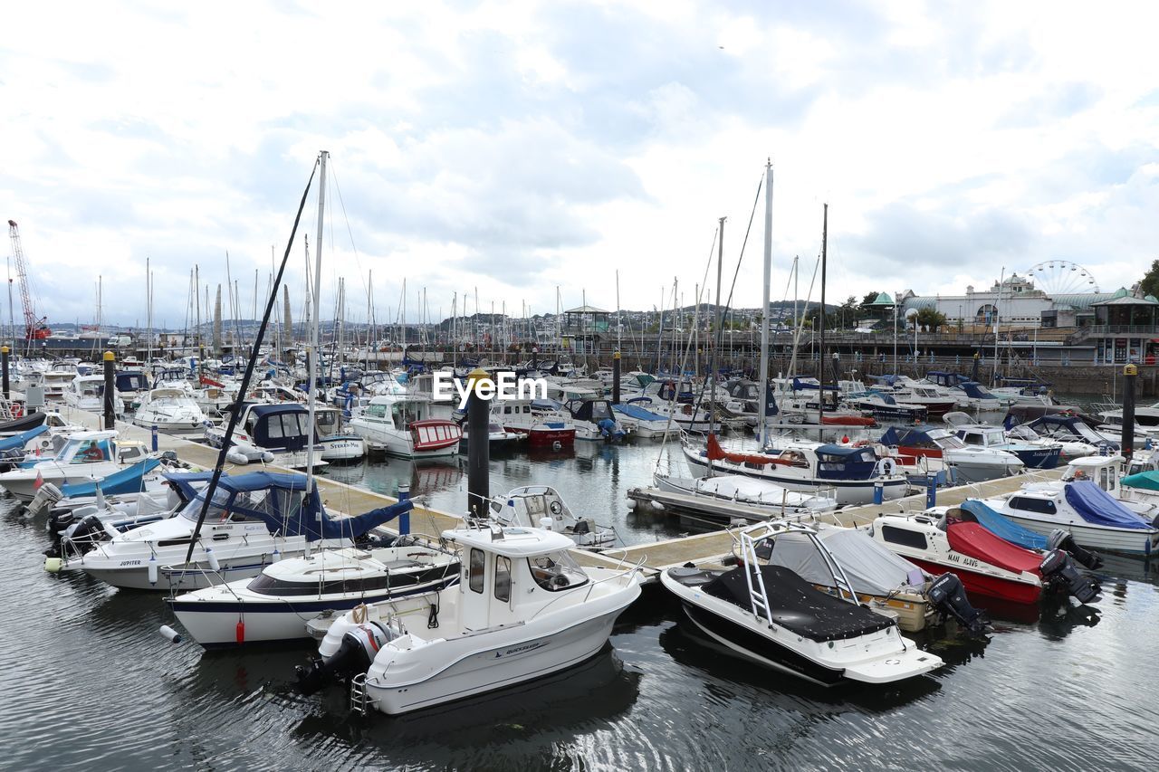 SAILBOATS MOORED IN HARBOR