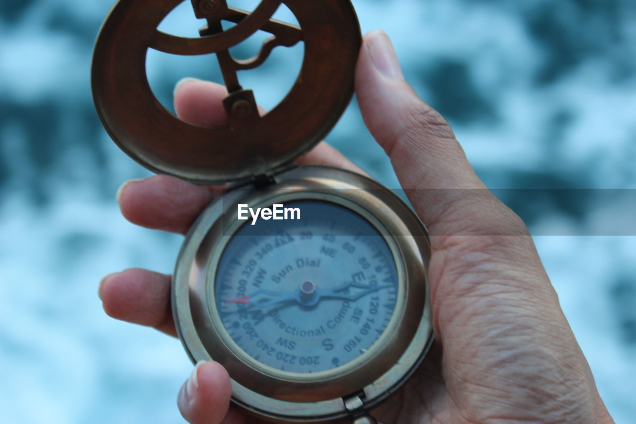 cropped hand of person holding pocket watch