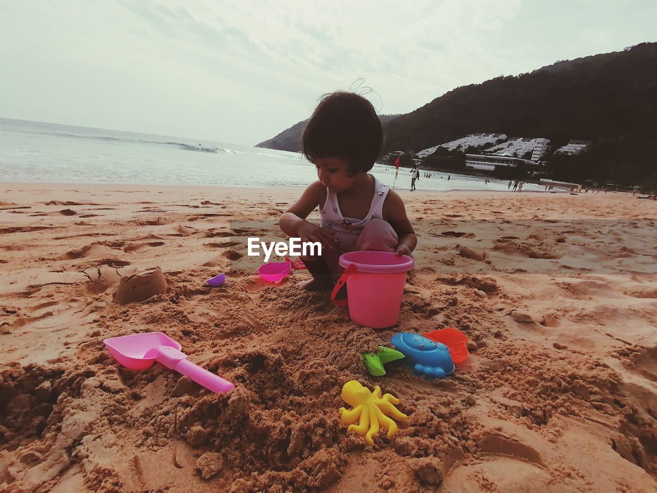 GIRL WITH TOY ON SHORE AT BEACH