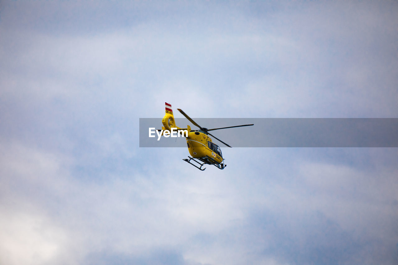 LOW ANGLE VIEW OF AIRPLANE IN MID-AIR AGAINST SKY