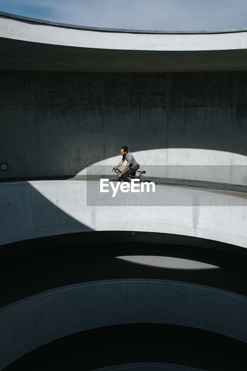 Man riding bicycle on bridge