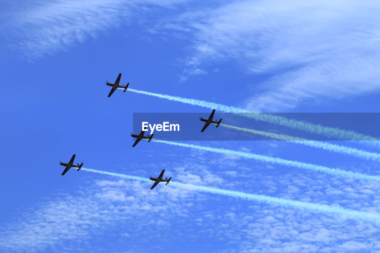 Low angle view of airplanes flying against sky