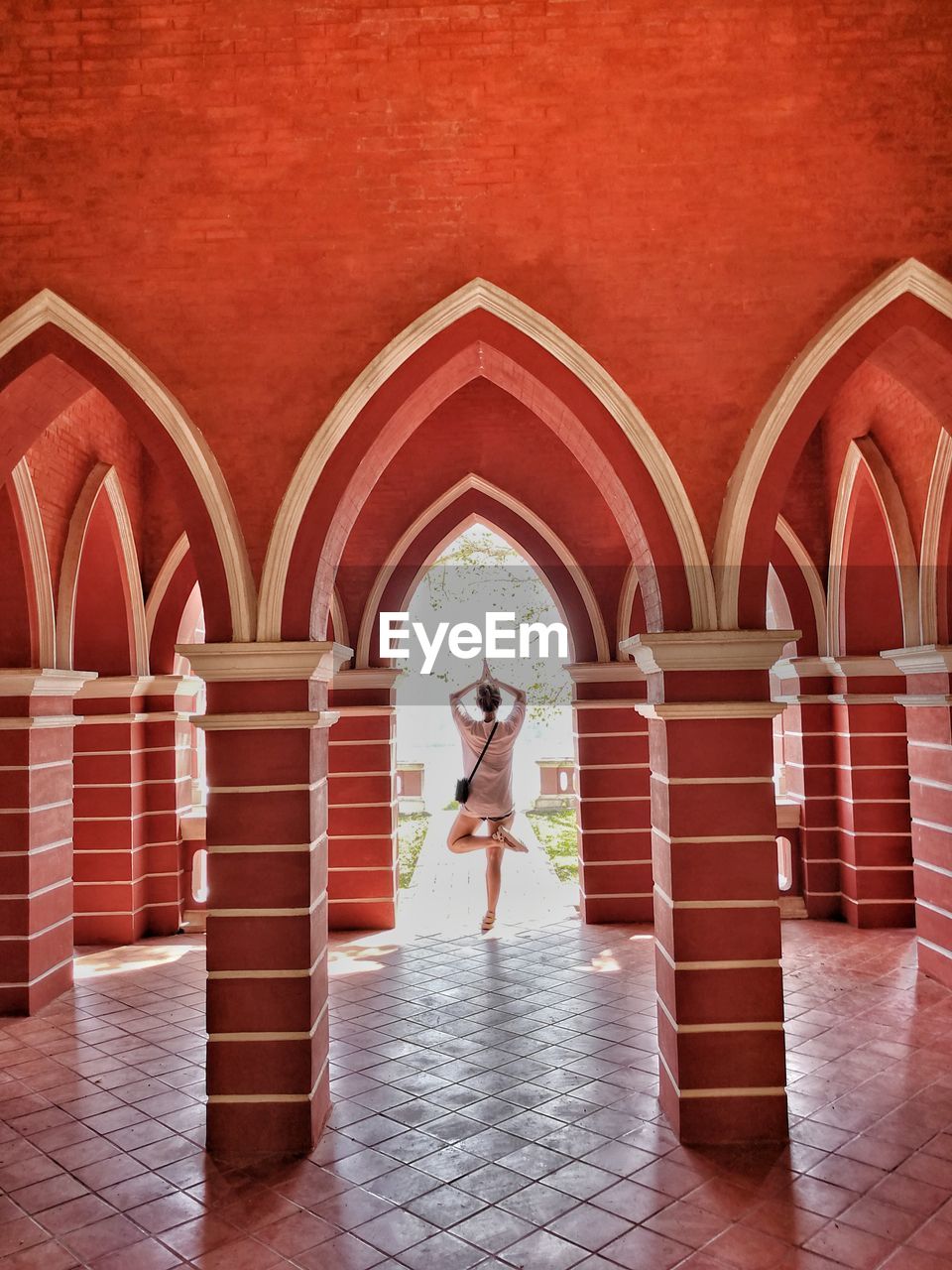 Rear view of woman doing yoga in building