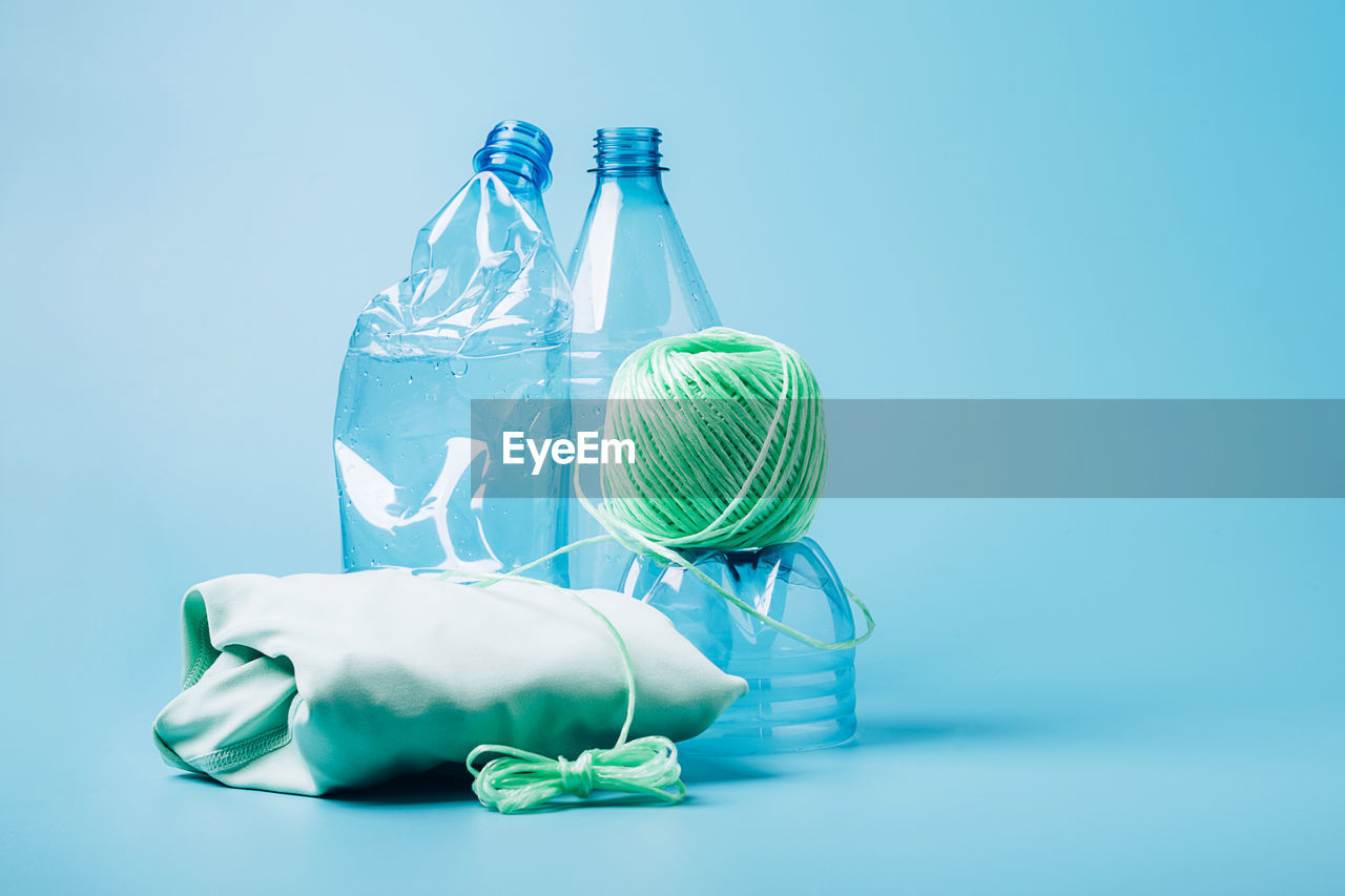 Green bottle against blue glass on table