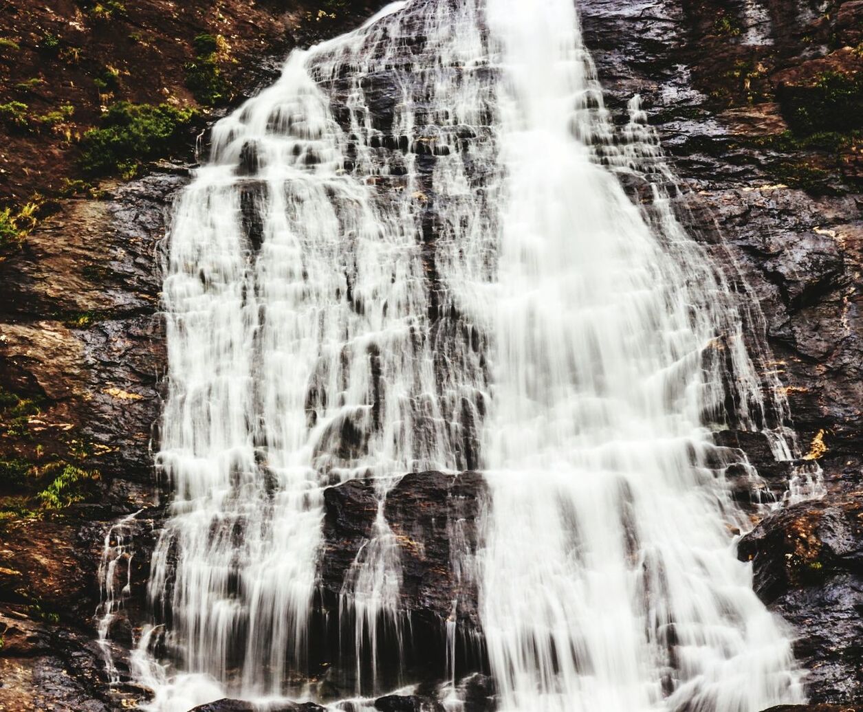 Low angle view of waterfall along rocks