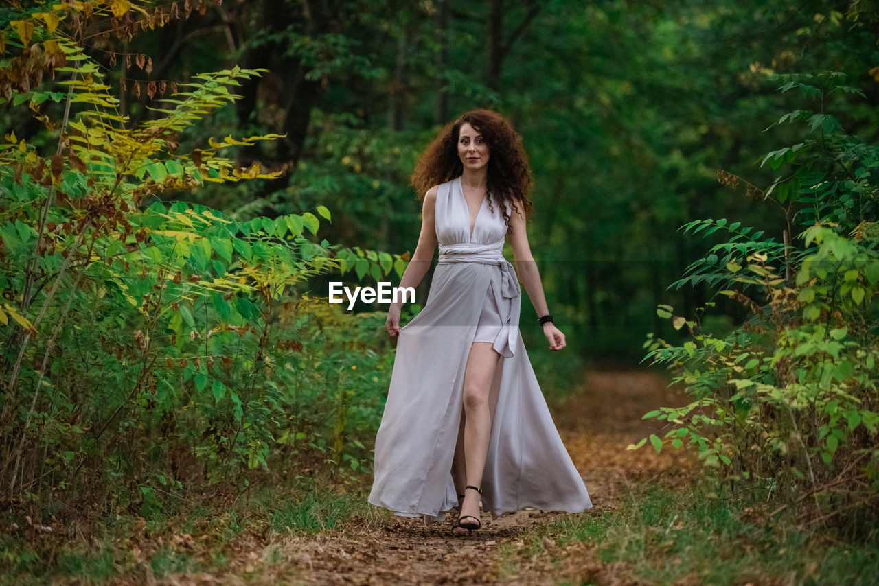 Full length of woman standing in forest