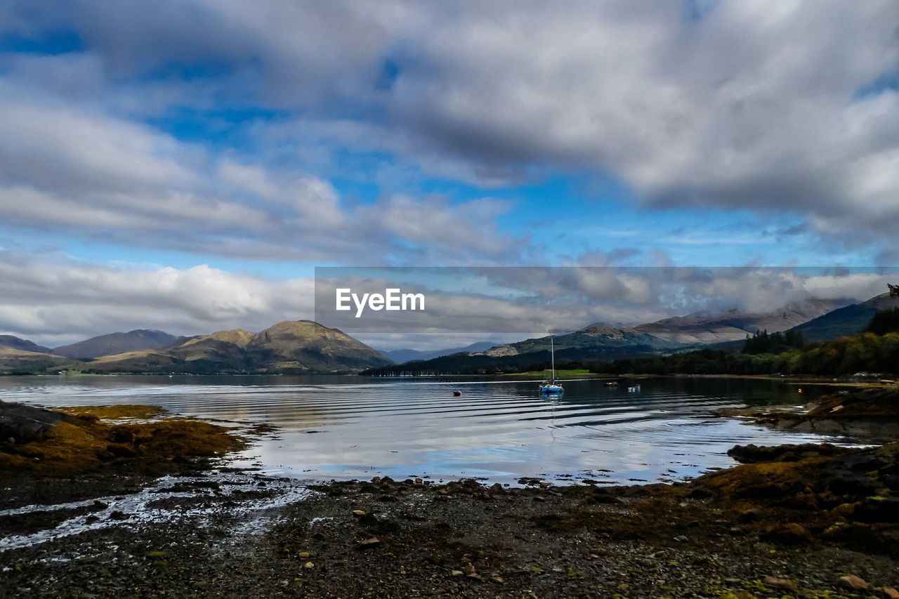 Scenic view of lake against cloudy sky
