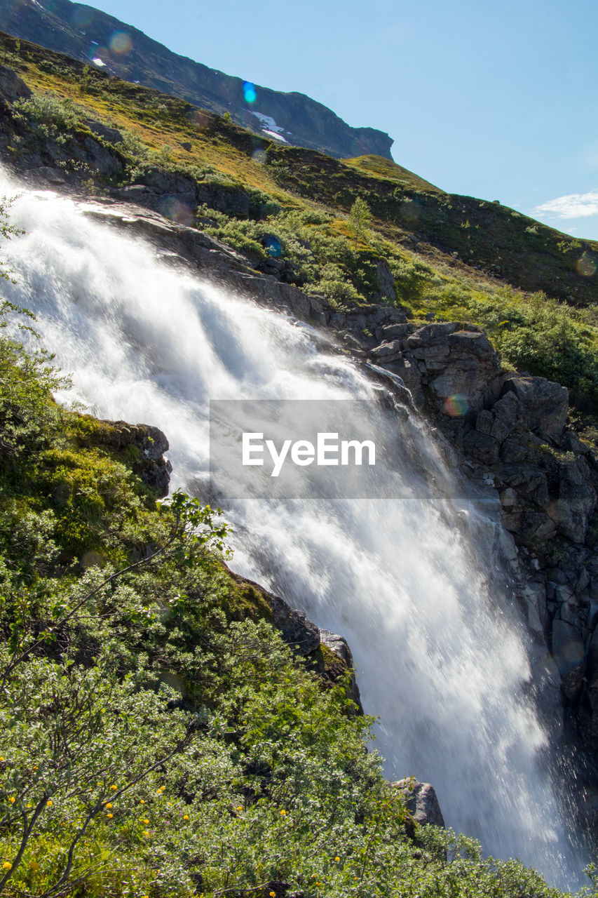 SCENIC VIEW OF WATERFALL AGAINST SKY