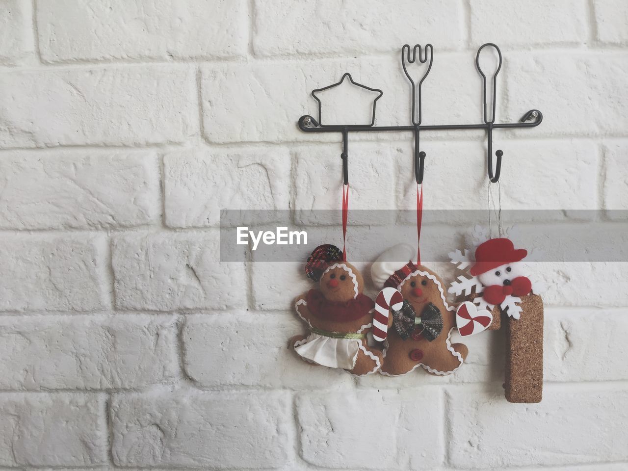 Close-up of gingerbread cookies hanging against white wall