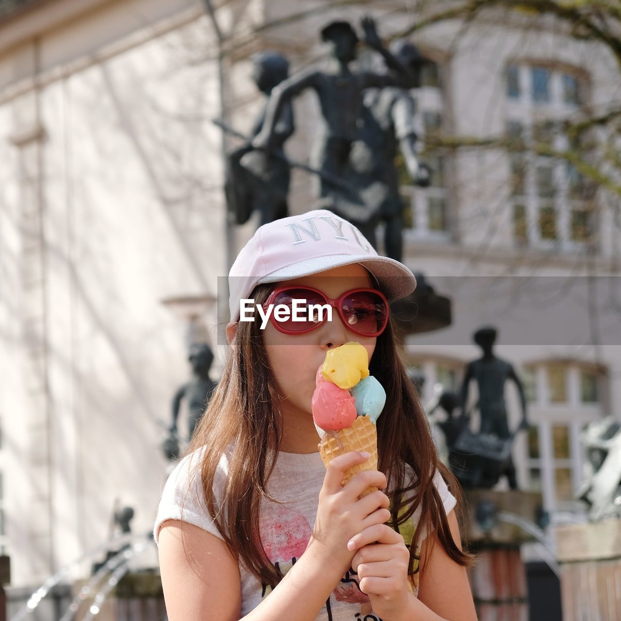 Girl eating ice cream cone in city