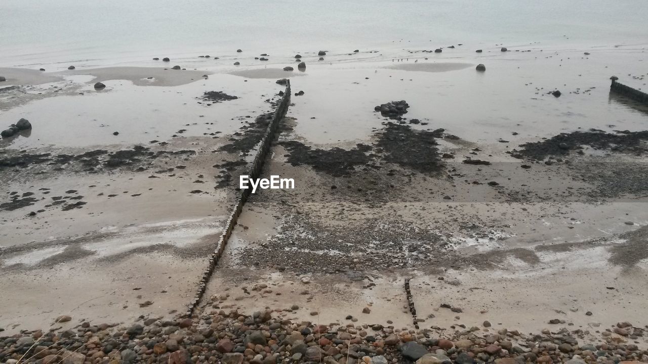 Scenic view of wet beach against sky