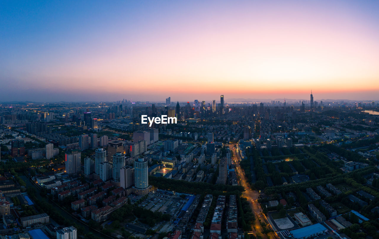 High angle view of illuminated buildings against sky during sunset