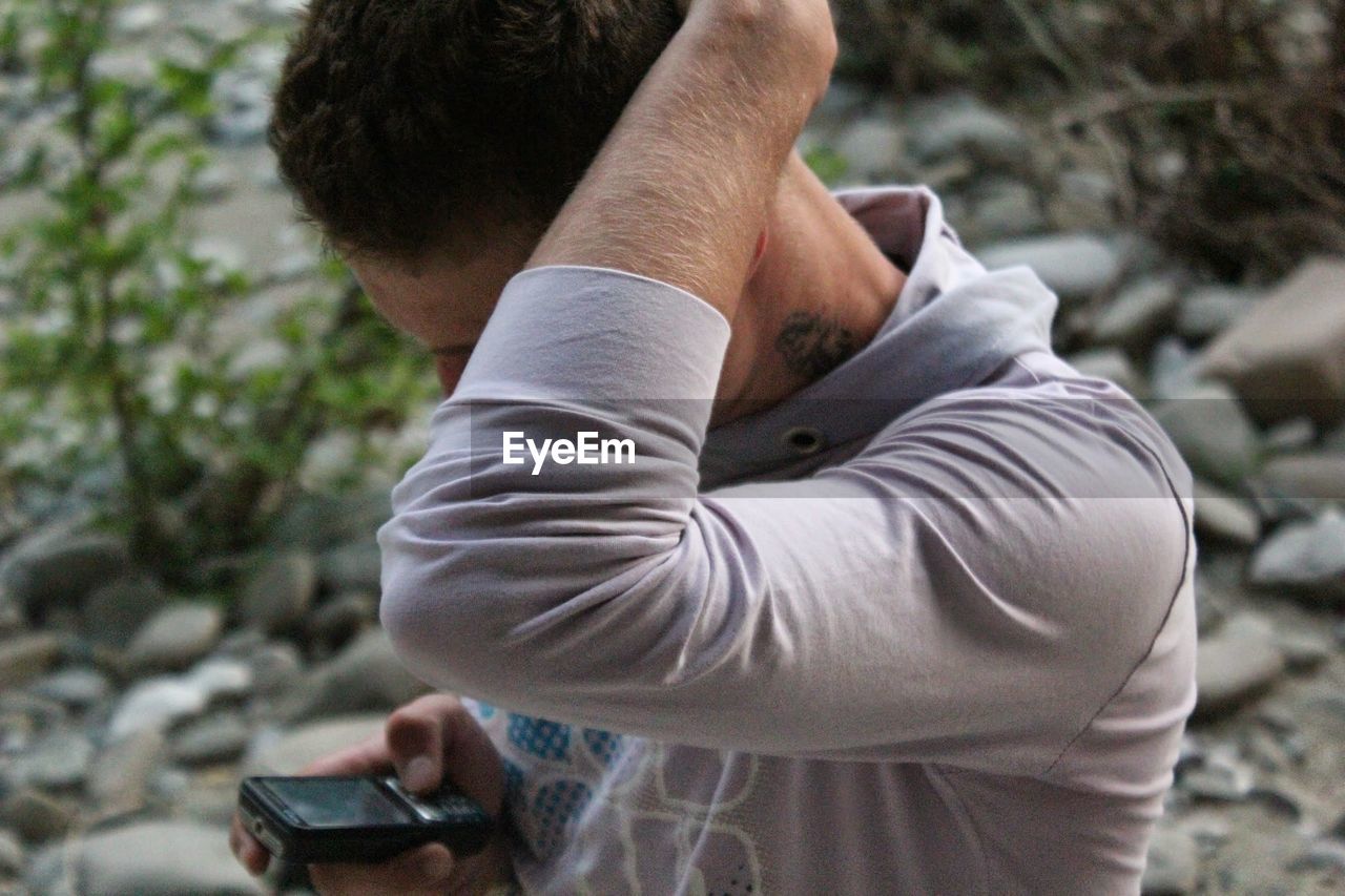 Man using mobile phone with hand in hair