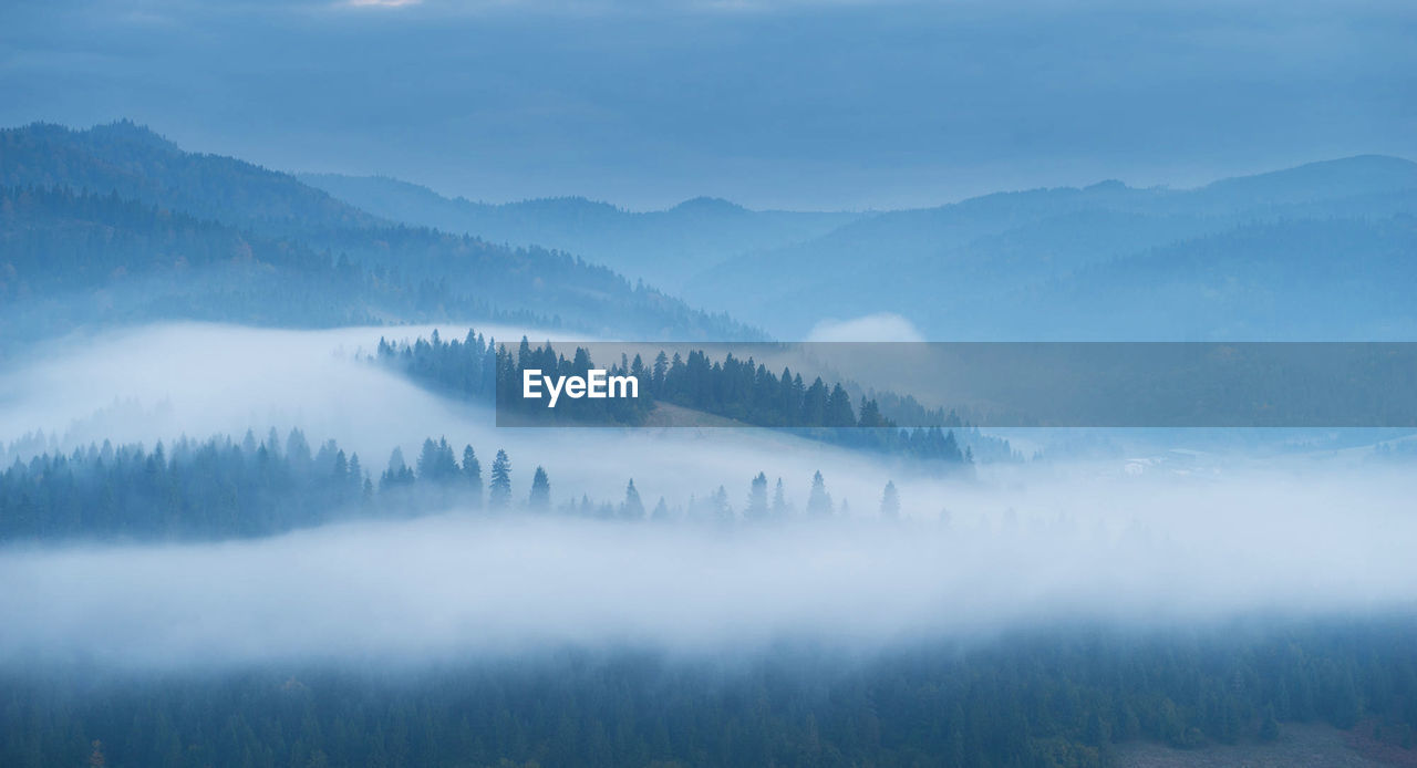 Scenic view of landscape against sky during foggy weather