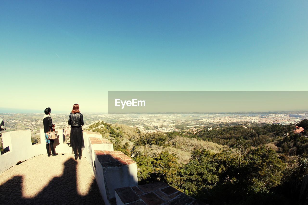 Women standing at observation point against sky