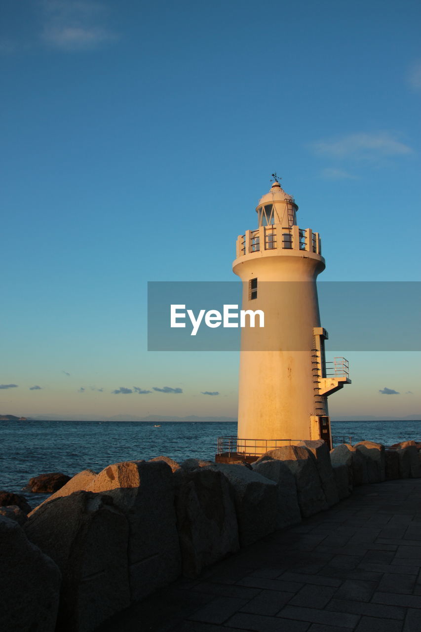 LIGHTHOUSE AMIDST SEA AGAINST SKY