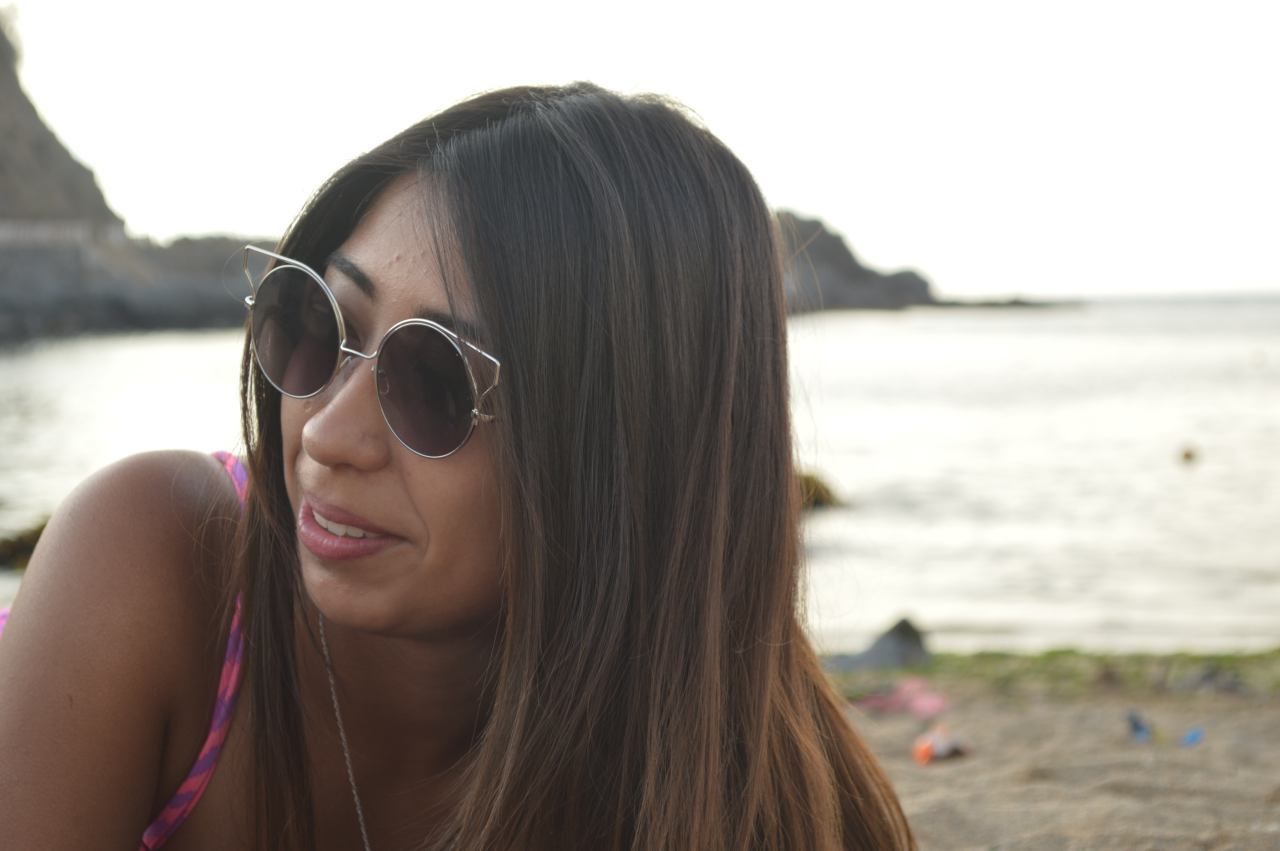 Close-up of happy woman at beach against sky