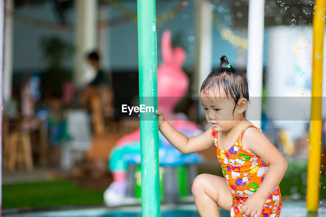 Close-up of cute girl standing at water park
