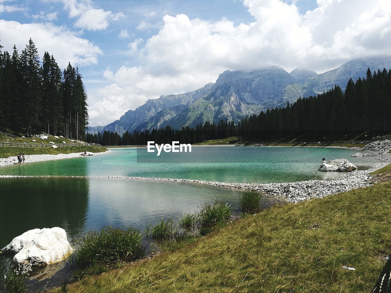 Scenic view of lake by mountains against sky