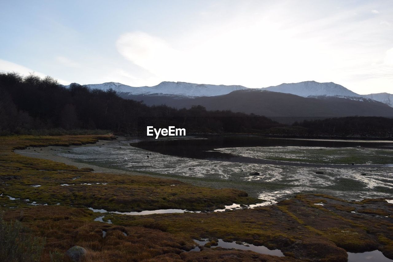 Scenic view of river and mountains against sky