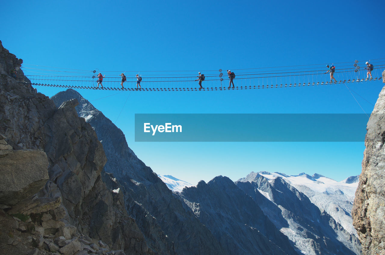 LOW ANGLE VIEW OF MOUNTAINS AGAINST CLEAR BLUE SKY