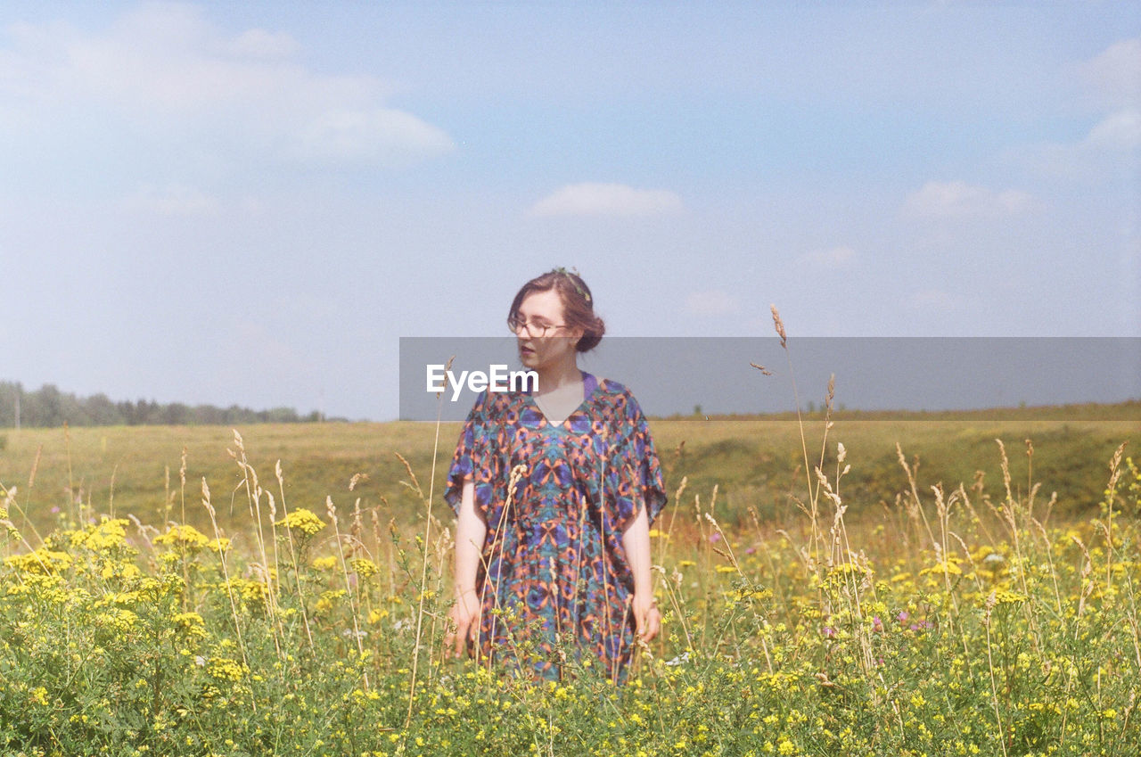 SMILING YOUNG WOMAN ON FIELD