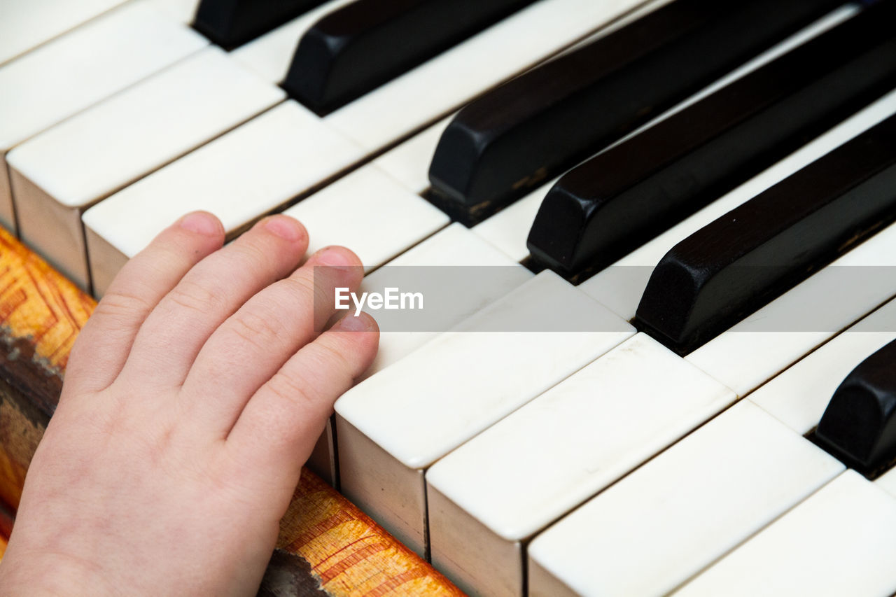 Cropped hand of baby boy playing piano