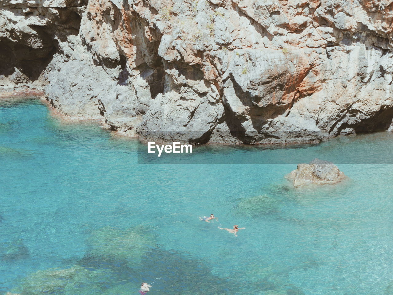 Tourists swimming close to rock formations