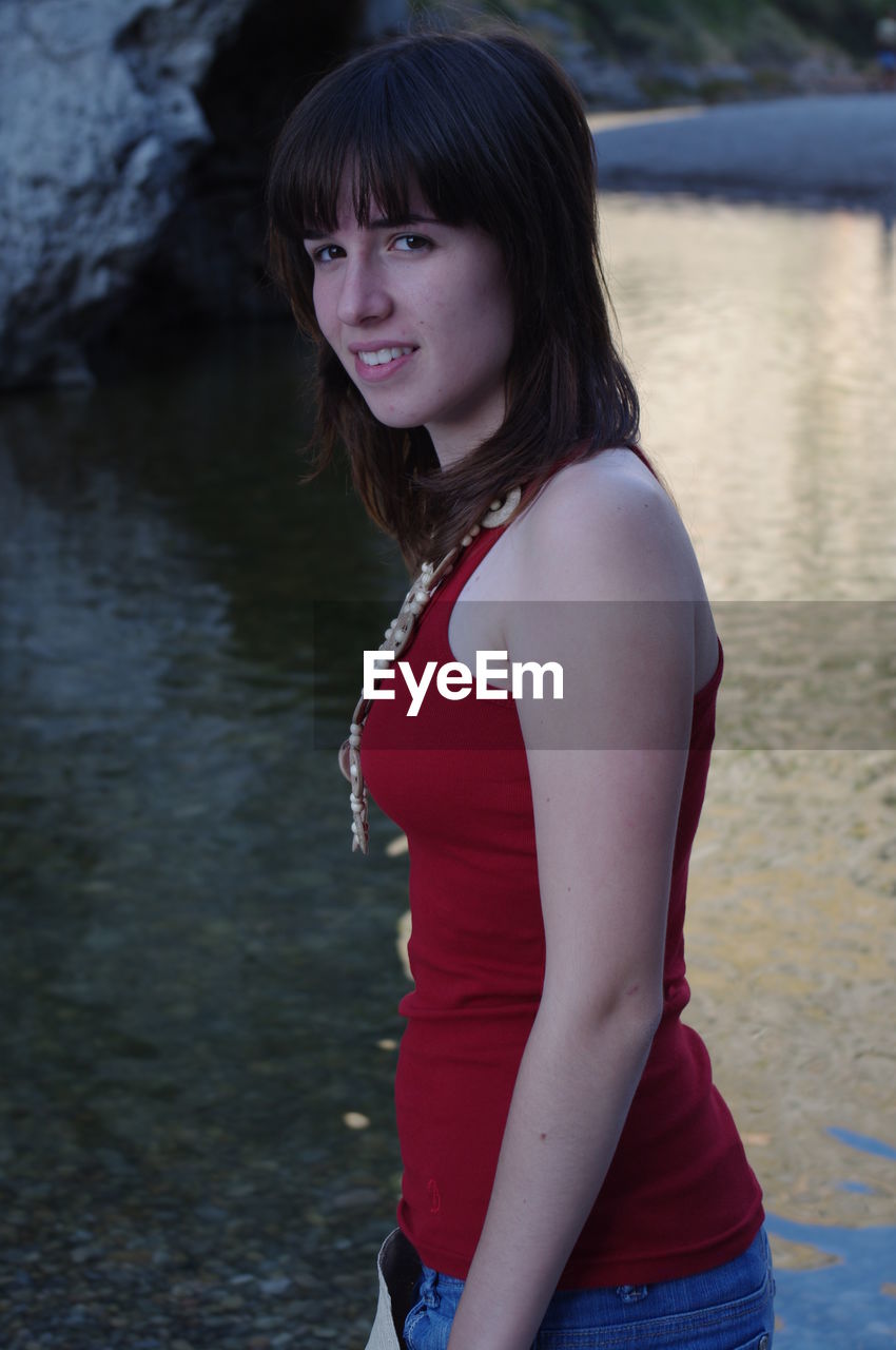 Side view portrait of woman standing at lakeshore