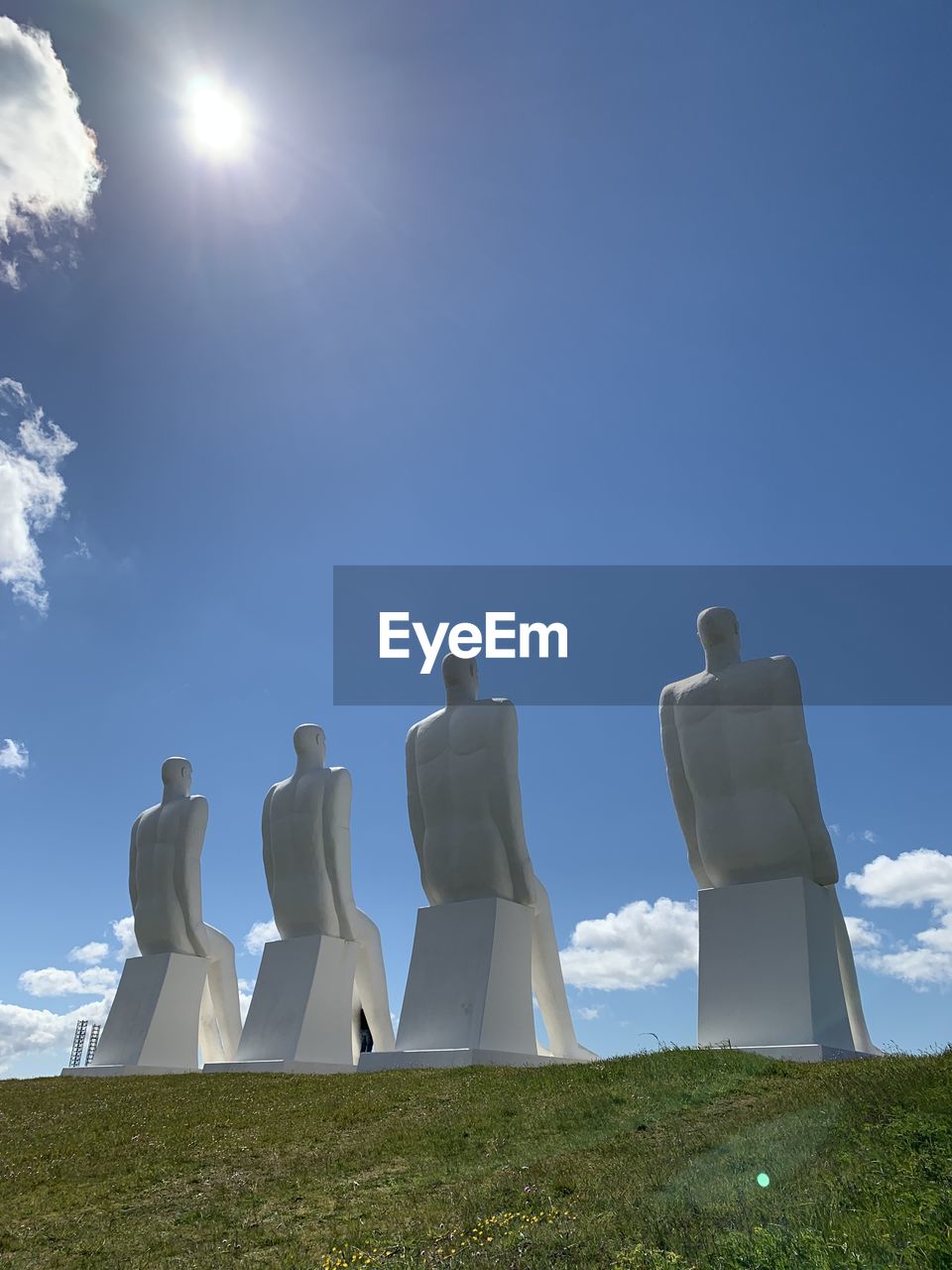 Low angle view of sculpture on field against sky