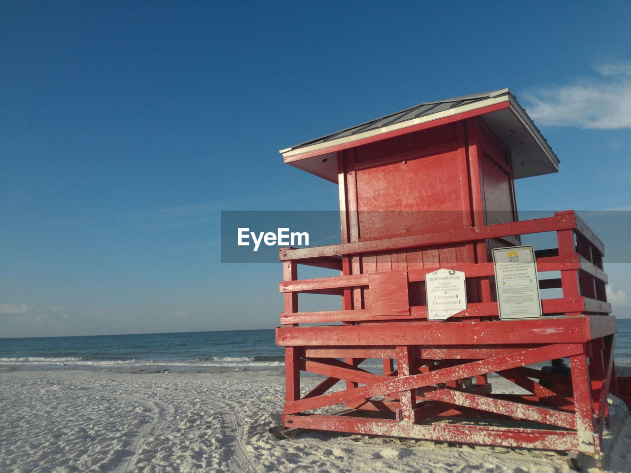 beach, sky, land, sea, water, nature, lifeguard hut, architecture, hut, sand, horizon over water, built structure, man made structure, horizon, lifeguard, scenics - nature, no people, wood, blue, tranquility, day, beauty in nature, tower, clear sky, tranquil scene, building exterior, red, travel destinations, outdoors, protection, security, cloud, holiday, building, sunlight, vacation, trip, sunny