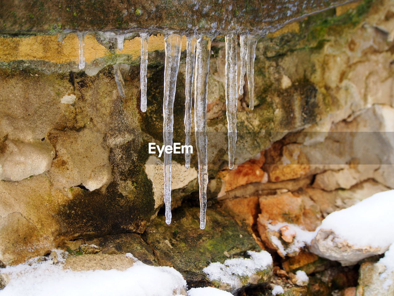 CLOSE-UP OF FROZEN ROCK IN WATER