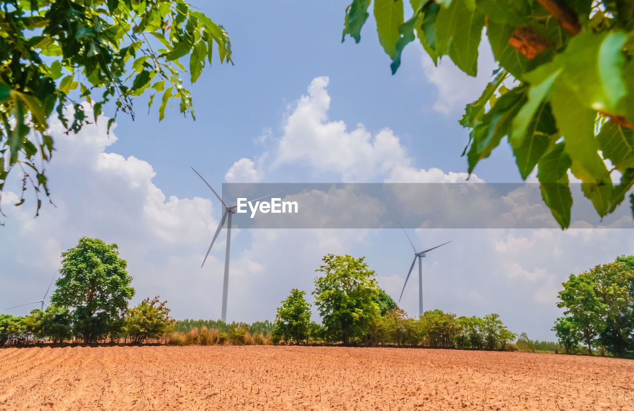 White windmill with blue sky and green environment, single wind turbine to generate electricity.