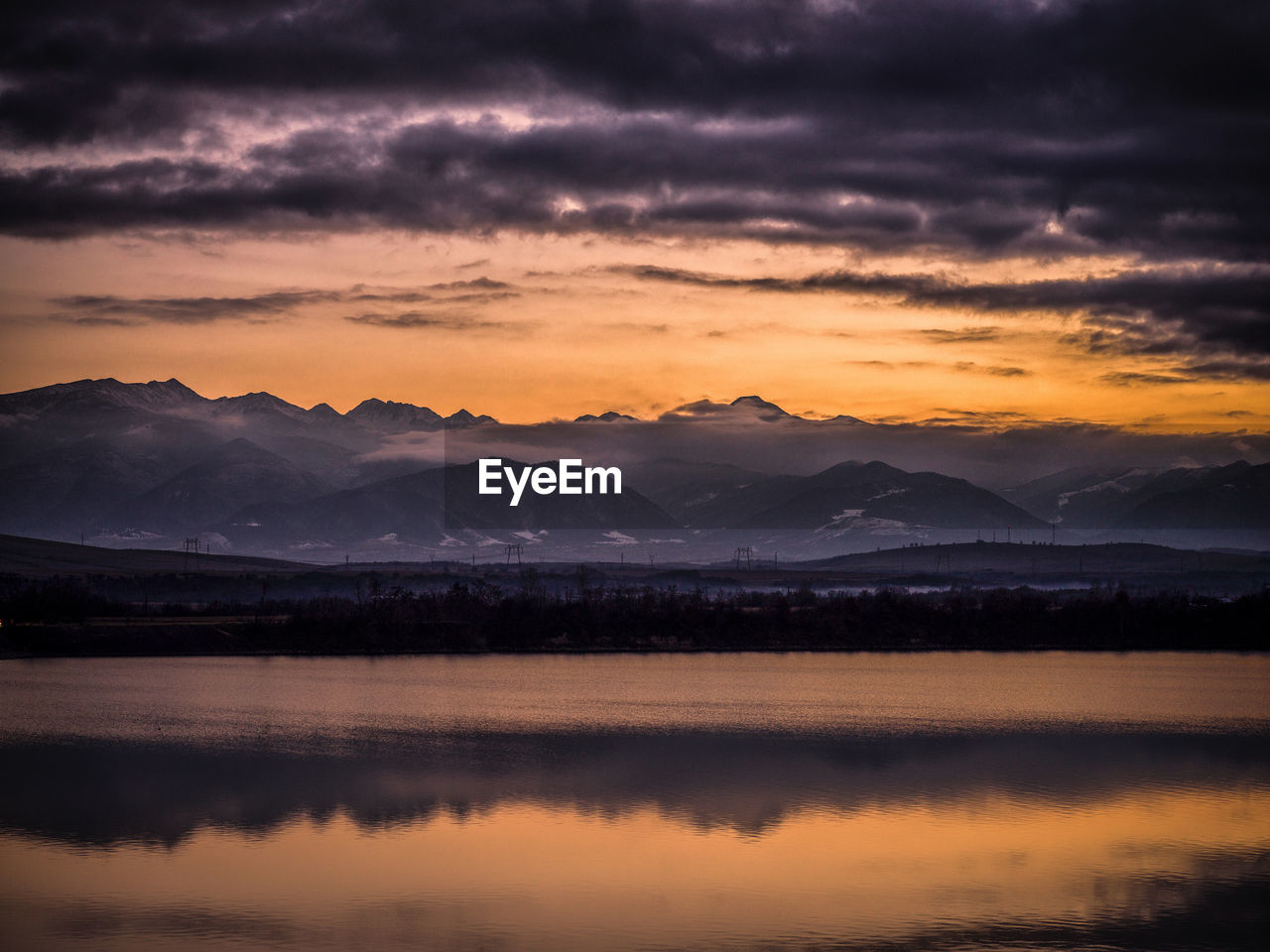 Scenic view of lake against sky during sunset