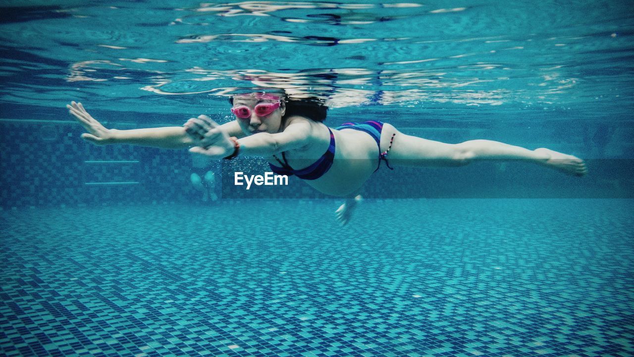 Portrait of pregnant woman swimming underwater