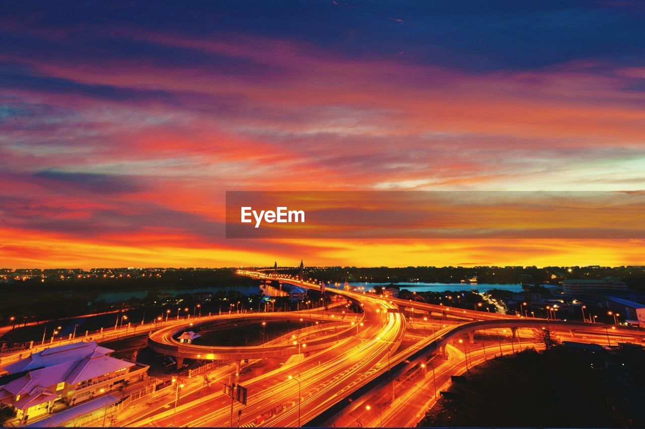 High angle view of overpass with bridge by river at dusk