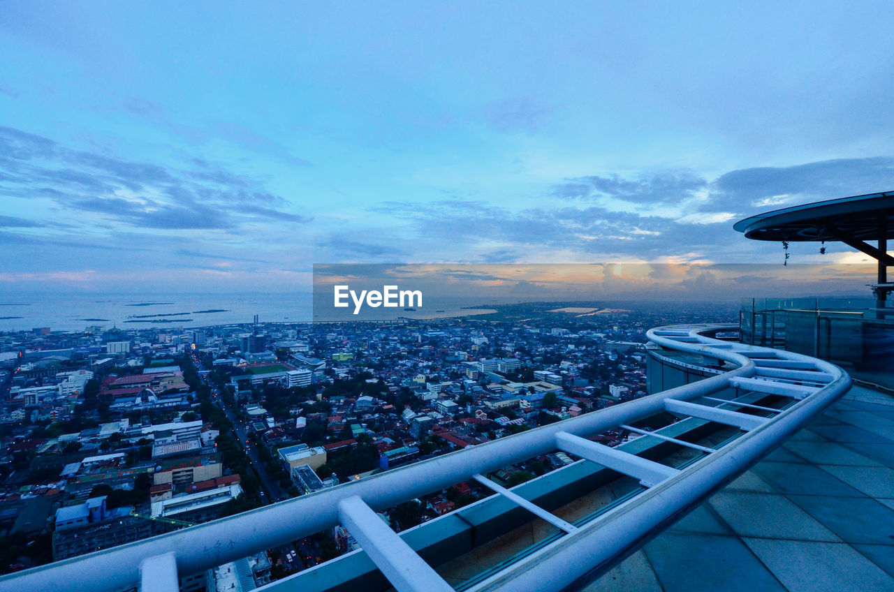 HIGH ANGLE VIEW OF ILLUMINATED BUILDINGS AGAINST SKY