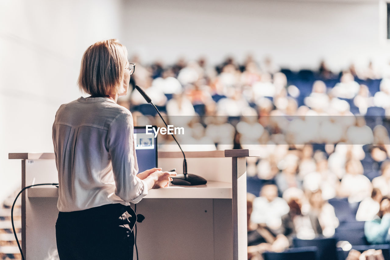 adult, women, one person, business, technology, rear view, business finance and industry, businesswoman, indoors, female, communication, standing, occupation, meeting, seminar, office, copy space, talking, focus on foreground, young adult, corporate business, white-collar worker